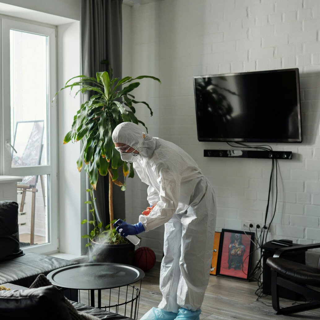 A lady removing odor from a living room with special chemicals