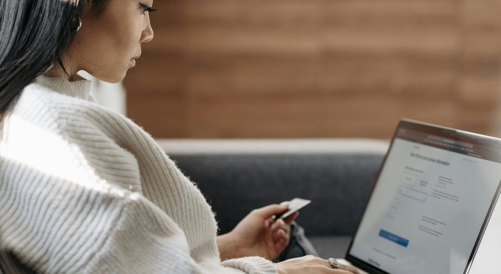 A woman paying for an invoice with her laptop and credit card.