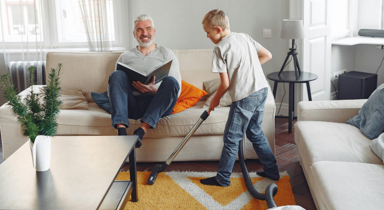 Child cleaning the carpet with his father