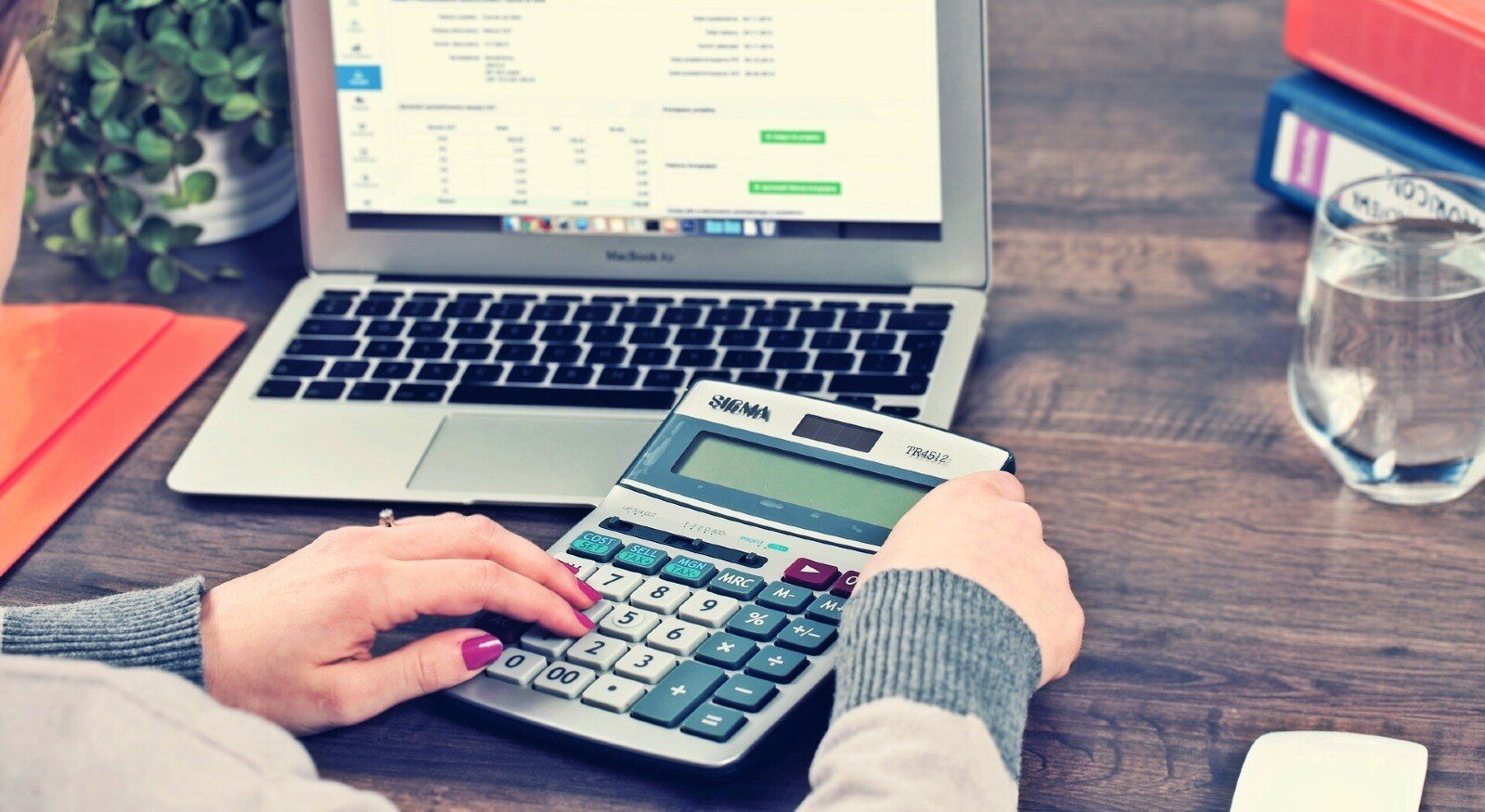 Woman budgeting with a laptop and a calculator